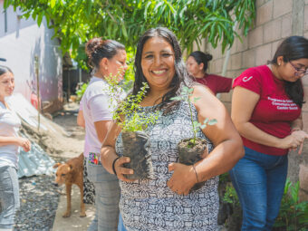 Die Teilnehmerin Lisseth mit zwei Baumsetzlingen